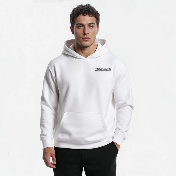 Sweat à capuche blanc homme "Édition Neige" signé Tourismo Clothing. Logo noir brodé avec damier façon course automobile sur la poitrine. Modèle sans cordon, coupe droite, poche kangourou. Le mannequin pose de face, regard sérieux, main dans la poche. Style épuré et racé, fond clair minimaliste.