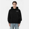 Homme portant un hoodie noir TOURISMO avec un jean clair, sur fond blanc
