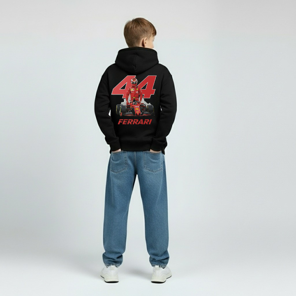 Vue arrière d’un enfant portant le hoodie noir Lewis Hamilton, numéro 44 rouge imprimé dans le dos, mot FERRARI blanc en dessous, capuche relevée, fond studio clair.