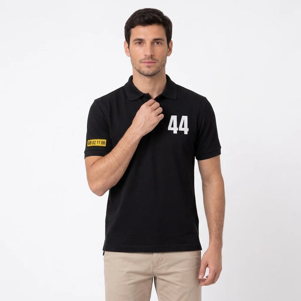 Homme portant le polo noir Lewis Hamilton, cadré en buste, 44 et plaque de manche visibles