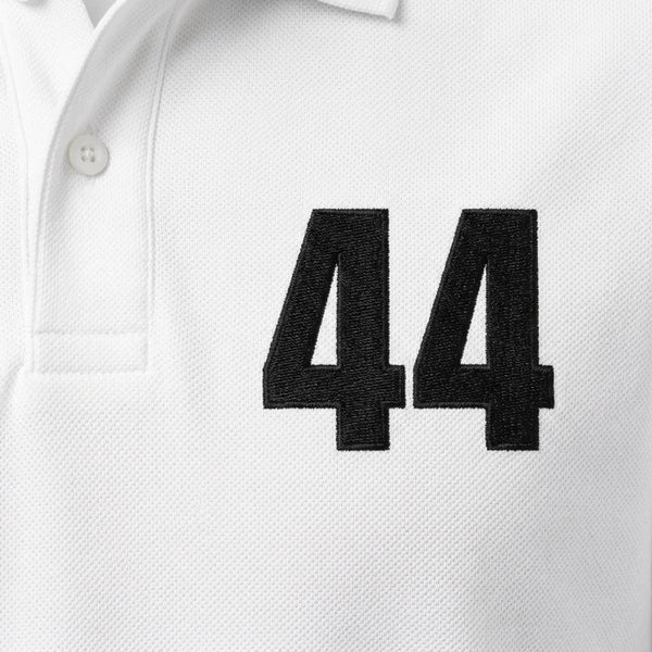 Gros plan sur le 44 brodé en noir du polo blanc Lewis Hamilton