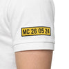 Plaque MC 26 05 24 brodée sur la manche du polo blanc Charles Leclerc, vue portée