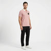 Homme portant le polo Porsche GT3 RS rose, vu de trois quarts