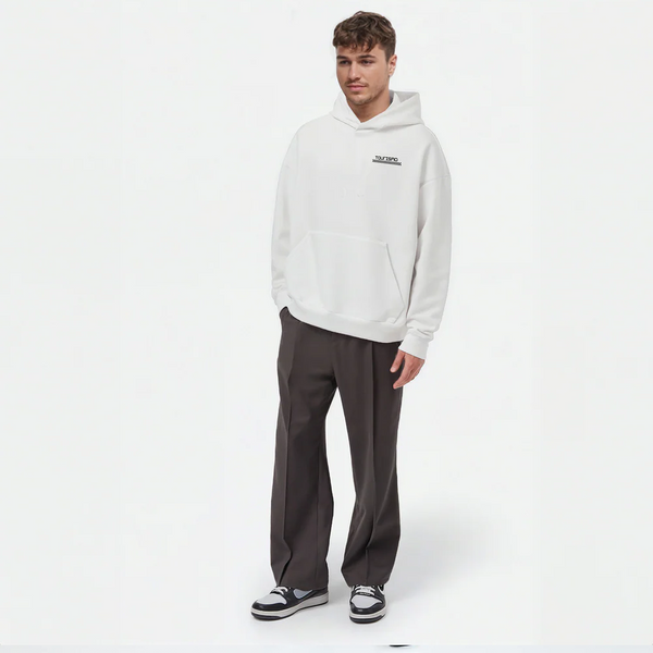 Sweat à capuche blanc TOURISMO porté par un homme, look streetwear avec pantalon foncé et baskets