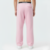 Vue de profil du pantalon de jogging Tourismo Paddock rose, montrant la coupe loose-fit et le tombé sur la chaussure.